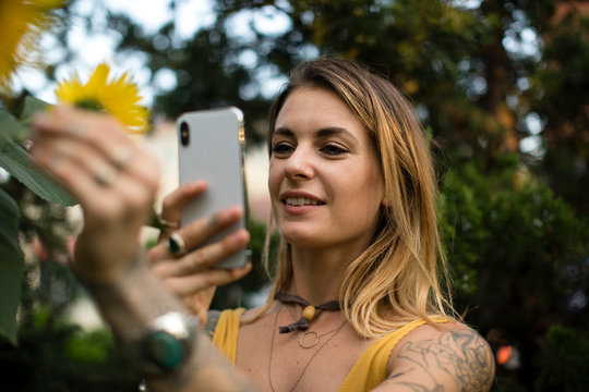 Woman taking a photo of a sunflower