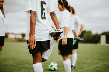 Female soccer team players stretching pre game