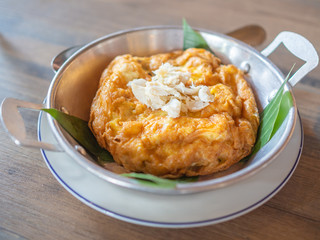Tasty Thai style omelette with crab meat on top in pan