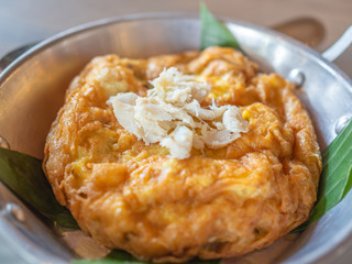Tasty Thai style omelette with crab meat on top in pan