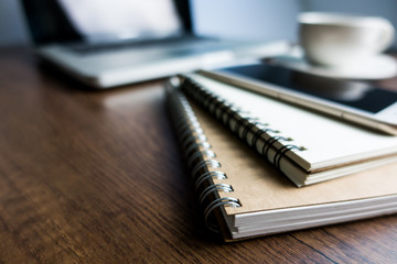 Close up office desk table with laptop, note book, mobile coffee and pen. Selective focus. Business concept. Copy space.