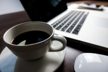 Close up office desk table with laptop, note book, mobile coffee and pen. Selective focus. Business concept. Copy space.