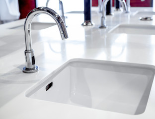 Faucet and sink decoration in public bathroom interior