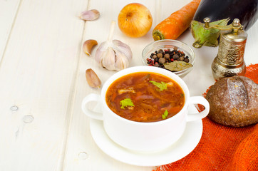 Soup with vegetables on white wooden surface