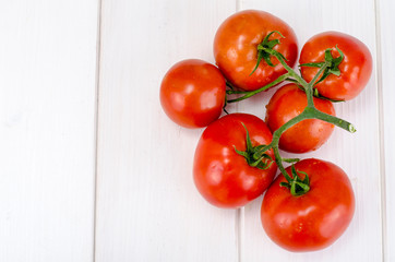 Branch of red tomatoes on white boards