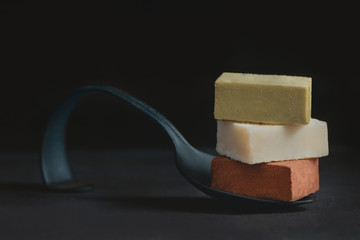 Assortment of soft chocolates on a black background with copy space. Milk and matcha Japanese gourmet chocolate close-up