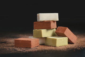 Assortment of soft chocolates on a black background with copy space. Milk and matcha Japanese gourmet chocolate close-up