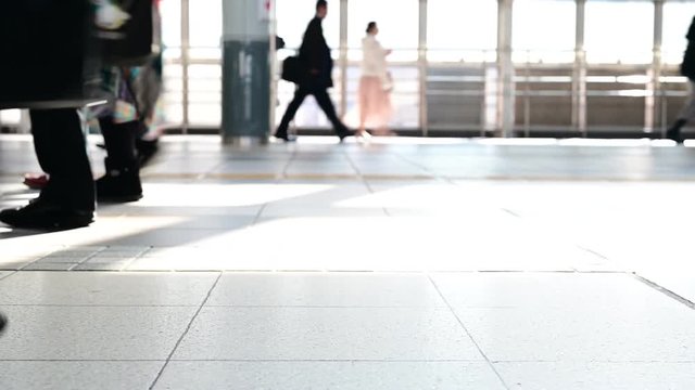 通勤時間中の駅構内。行き交う人々。足元の視点。