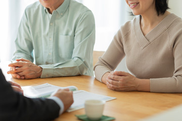 中年夫婦に説明するビジネスマン 