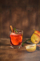 homemade hot mulled pear cider with a cinnamon stick on a wooden background