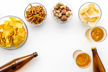 Snacks and beer. Chips, nuts, rusks near beer on white background top view space for text