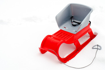 Red children sledges on white snow background