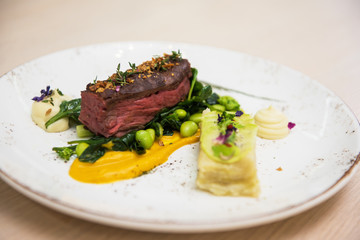 Beef meat with green peas, sweet potato mousse, roasted spinach and zucchini gratin