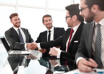 handshake financial partners over the negotiating table.