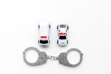 Police concept. Police car toy and handcuff on white background top view copy space