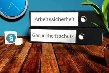 Sicherheit am Arbeitsplatz. Etiketten auf Aktenordner beschriftet mit den Begriffen Arbeitssicherheit und Gesundheitsschutz