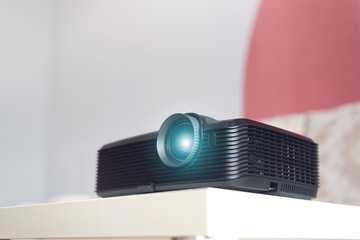 Black projector on a table. Home movie theatre concept background.