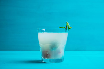 Old fahioned lychee cocktail on the rustic background. Selective focus. Shallow depth of field. 