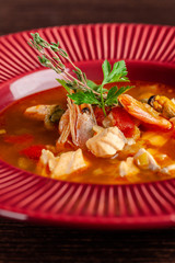 French cuisine concept. Classic French fish soup of seafood, shrimps, mussels, squid, potatoes,...