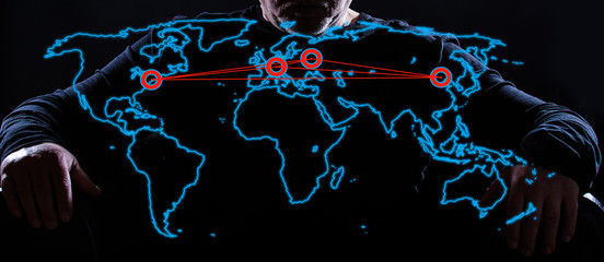 a world map with political power centers, in the background sits a man