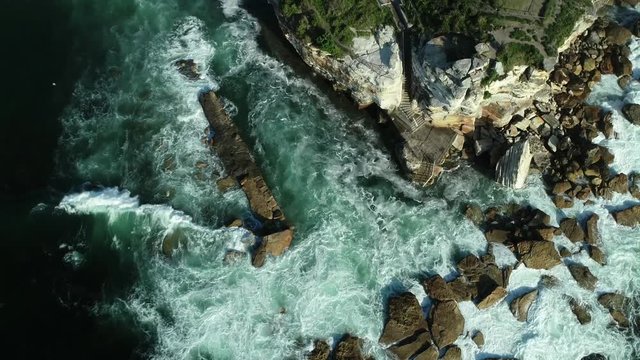 Ascent over sea cliffs from above with waves and rocks, Eastern beaches, NSW, Australia, 4K