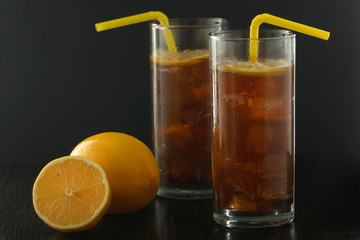 Glasses with cuba libre cocktail or cola with ice or cold tea with lemon