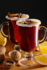 Two cups with ready mulled wine with anise, cinnamon and nuts around