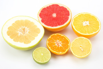 Fototapeta na wymiar cut pieces of different citrus fruits on white background