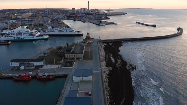 Aerial of ferry as it is leaving the harbor in Helsingborg, Sweden. Going forward paning upwards during sunset.