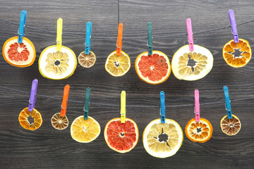 dried pieces of citrus fruits hang on clothespins