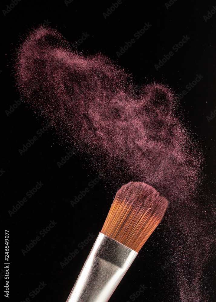 Wall mural close up powder splash and brush for makeup artist or beauty blogger in black background