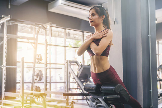 Young woman doing sit ups exercise with machine at fitness gym..