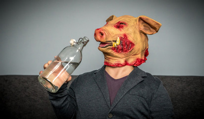 Unrecognizable man with a bloody pig mask. Horror scene