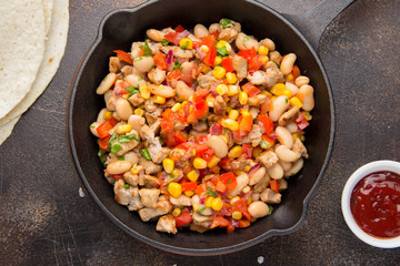 Preparation of filling for burritos in tortillas with meat, vegetables, white beans, red pepper, corn. Delicious lunch, Mexican food, homemade snack