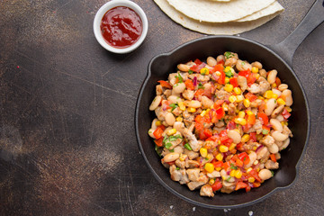 Preparation of filling for burritos in tortillas with meat, vegetables, white beans, red pepper, corn. Delicious lunch, Mexican food, homemade snack