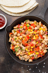 Preparation of filling for burritos in tortillas with meat, vegetables, white beans, red pepper, corn. Delicious lunch, Mexican food, homemade snack