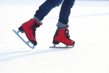 Naklejka premium Female legs in skates on an ice rink