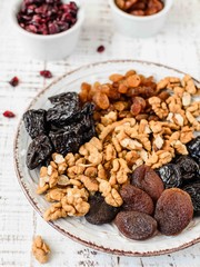 Nuts and dried fruit mix, healthy and wholesome food. Vintage wooden background, selective focus