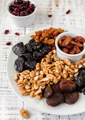Nuts and dried fruit mix, healthy and wholesome food. Vintage wooden background, selective focus
