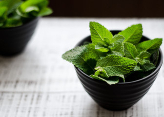 Fresh green mint on the white old wooden table. Soft selective focus