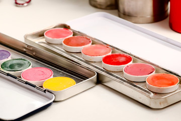 Makeup colorful eyeshadow palette in metal cases isolated on white background