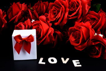 Gift box, Wooden letters word "LOVE" and red rose on black background