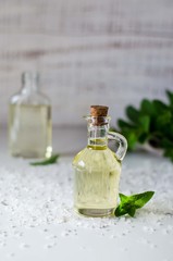 Natural Mint Essential Oil in a Glass Bottle with Fresh Mint Leaves