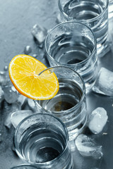 Cold vodka in shot glasses on a black background.