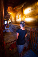 Tourist visits Wat Phra Chetuphon Reclining Buddha Bangkok Thailand