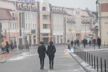 Two young women walk on the streets of Minsk holding hands