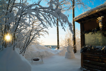 Snowman in a clearing near the winter gazebo .