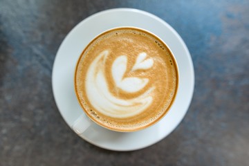 Top view, latte art, cup of coffee on gray stone tabletop