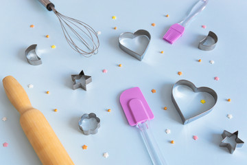 Cookie cutters, whisk and rolling pin on dark background. Bakery and confectioner concept. Baker's tools