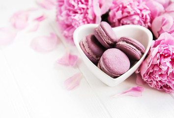 Obraz na płótnie Canvas Pink peony flowers with macarons